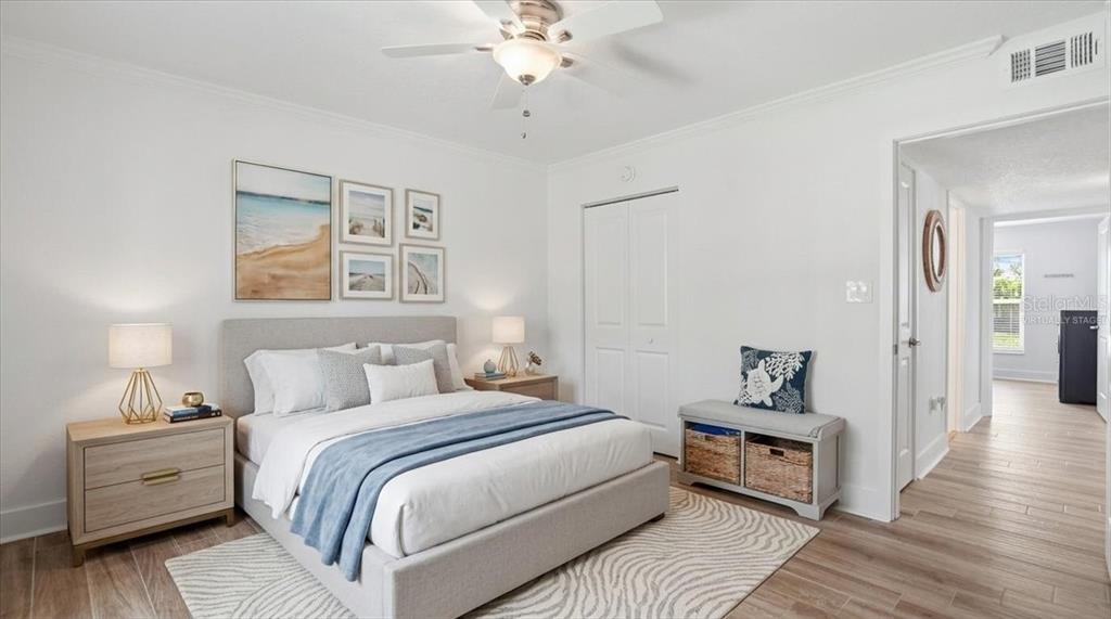 8911 Blind Pass Road, Unit 118 St. Pete Beach, FL 33706 - Photo 21 of 34 a bedroom with a bed and a chandelier