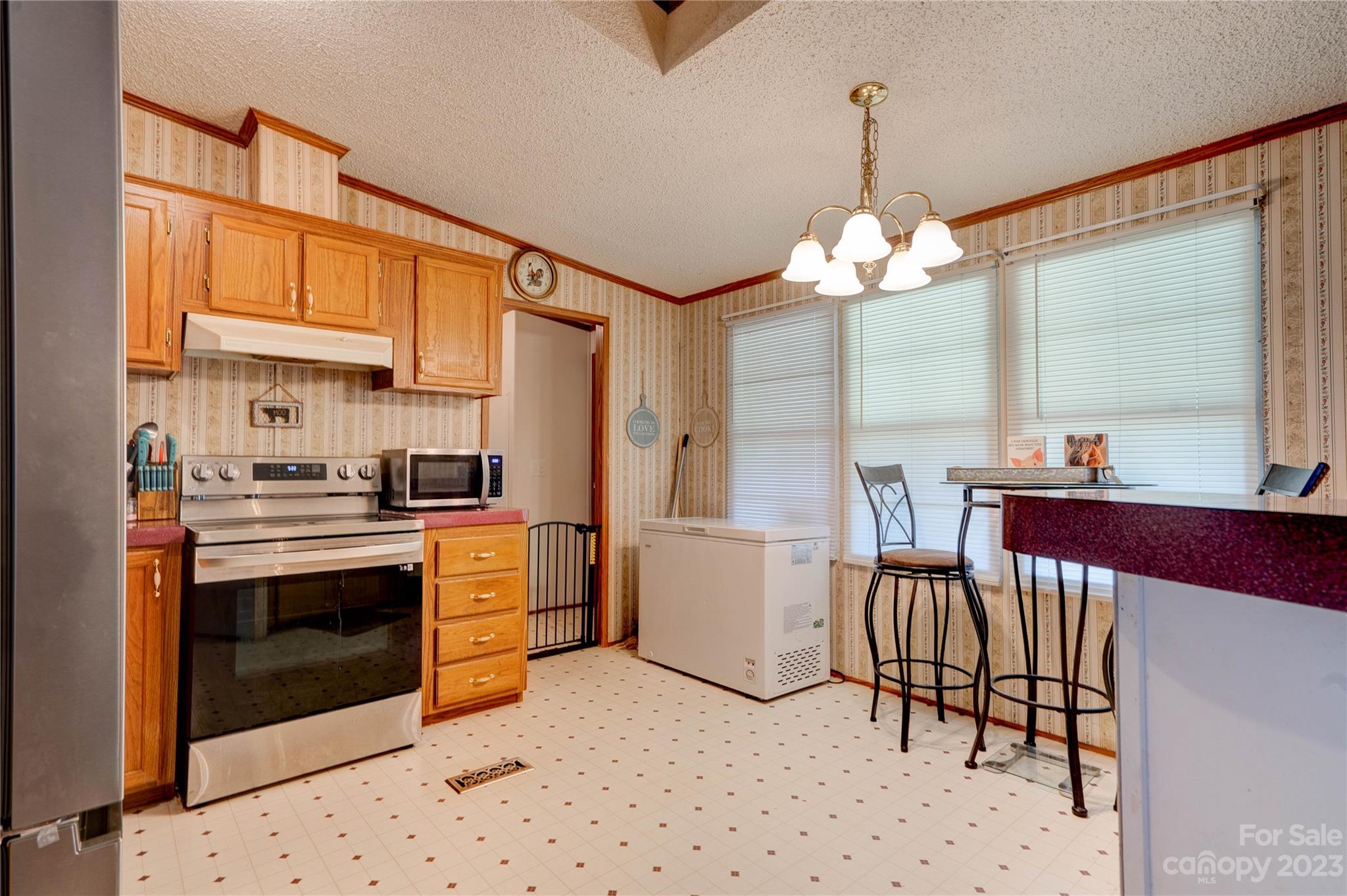 389 Shires Road Ellenboro, NC 28040 - Photo 22 of 30 a kitchen with stainless steel appliances kitchen island granite countertop a table chairs in it and a window