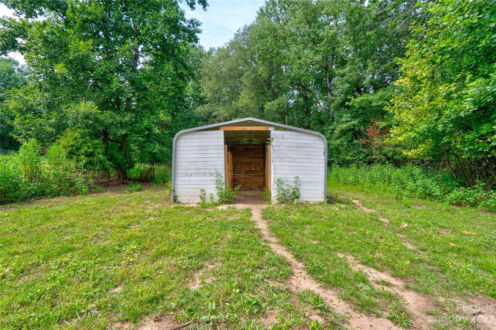 389 Shires Road Ellenboro, NC 28040 - Photo 7 of 30 a backyard of a house with plants and large tree