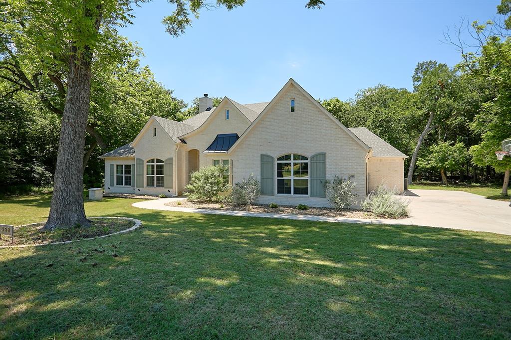 358 Glade Valley Road Azle, TX 76020 - Photo 34 of 35 Brick exterior featuring arched windows with shutters, a gabled roofline, and a prominent chimney