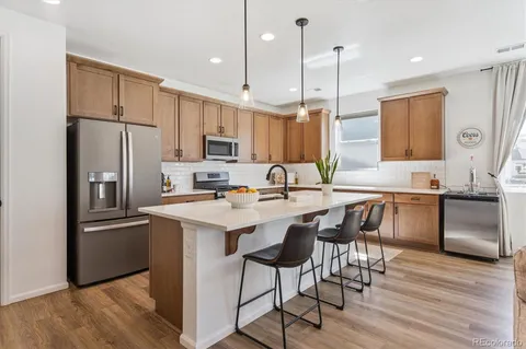 a kitchen with a sink a counter space appliances and cabinets