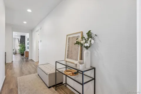 a view of a hallway with wooden floor and a potted plant