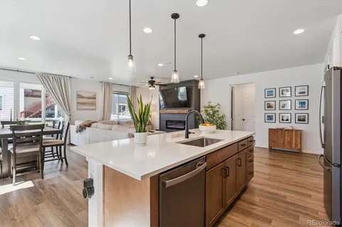 a kitchen with stainless steel appliances granite countertop a sink a stove and a wooden floors