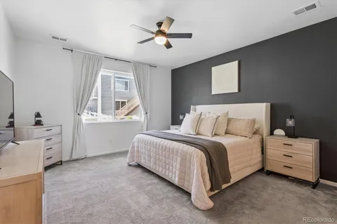 a spacious bedroom with a bed and a ceiling fan