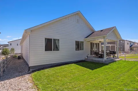 a view of a backyard with table and chairs potted plants and large tree