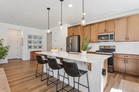 a kitchen with stainless steel appliances a stove a sink refrigerator and a wooden cabinets