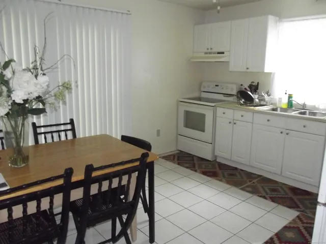 a kitchen with a table chairs sink and cabinets