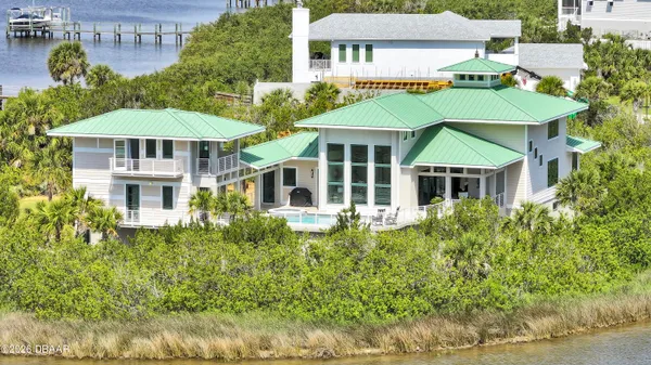 a view of a white house with a yard and potted plants