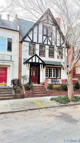 a front view of a building with large trees