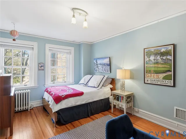 a bedroom with a large bed and a chandelier