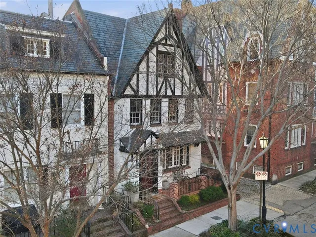 a front view of a building with large trees