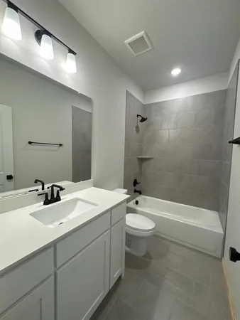 a bathroom with a double vanity sink toilet mirror and bathtub