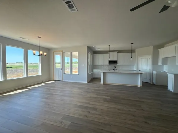 a view of kitchen with granite countertop cabinets and refrigerator