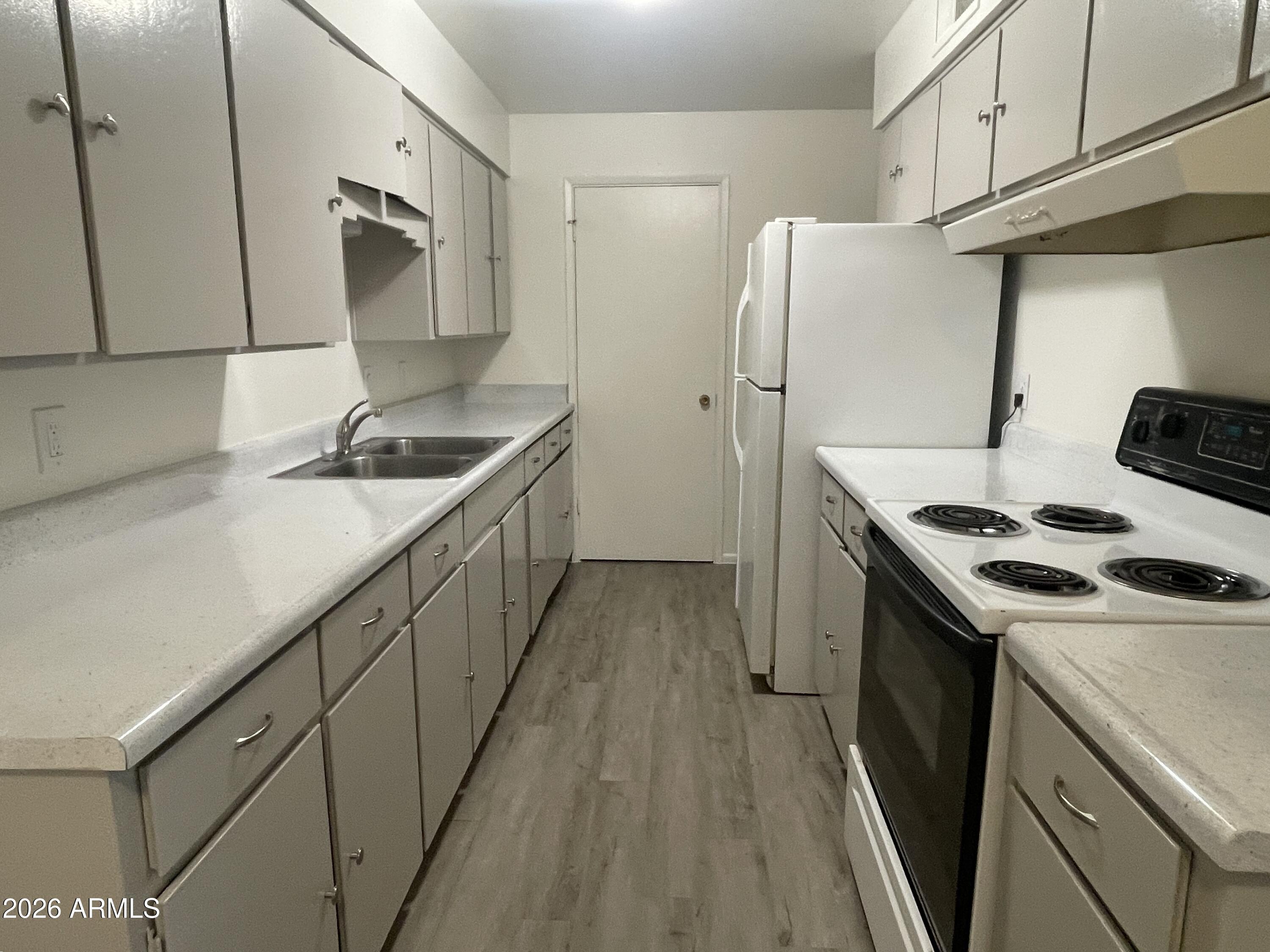 a kitchen with a sink a refrigerator and a stove
