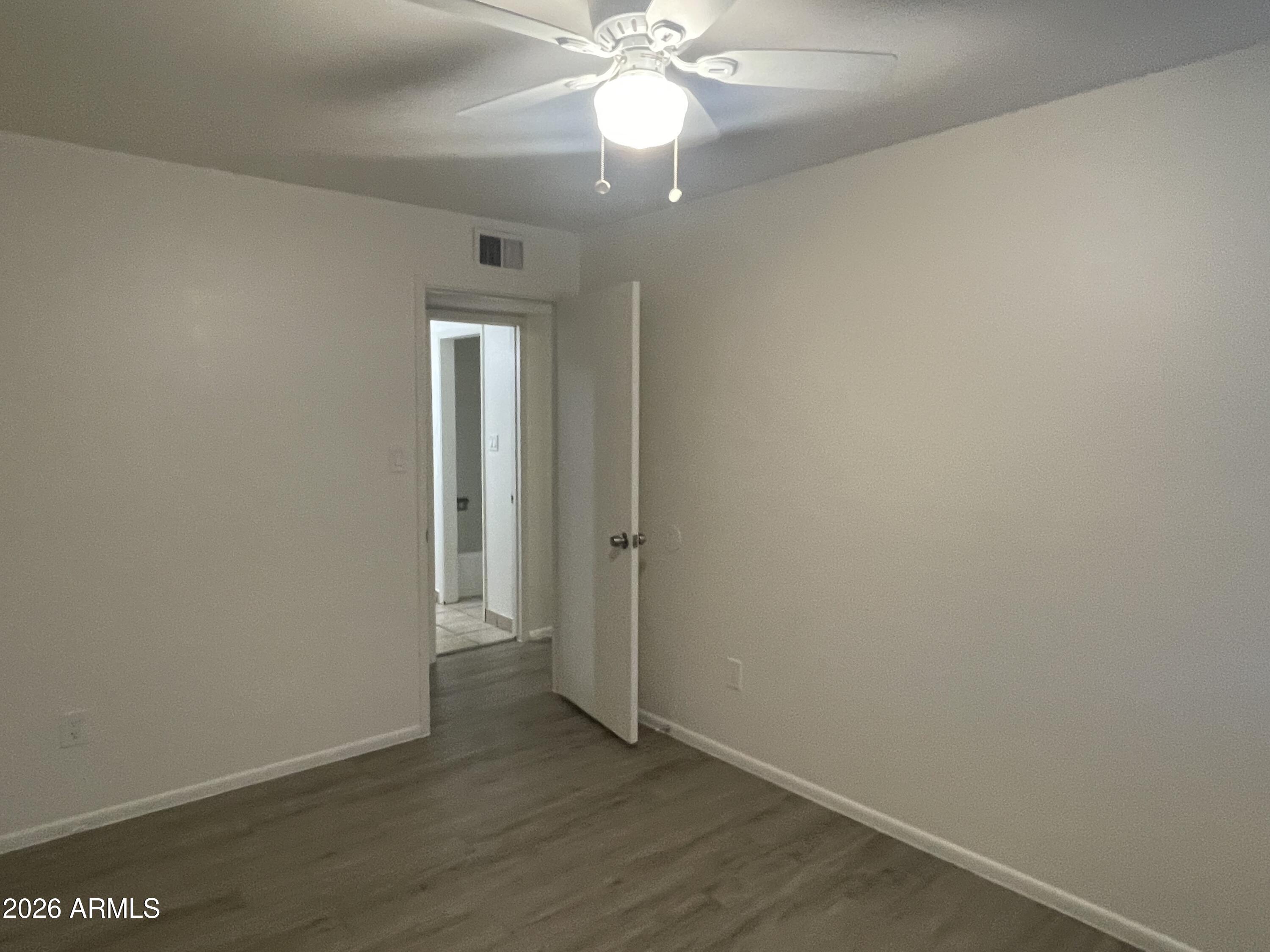 4719 North 15th Avenue, Unit 4 Phoenix, AZ 85015 - Photo 11 of 13 an empty room with wooden floor and a ceiling fan