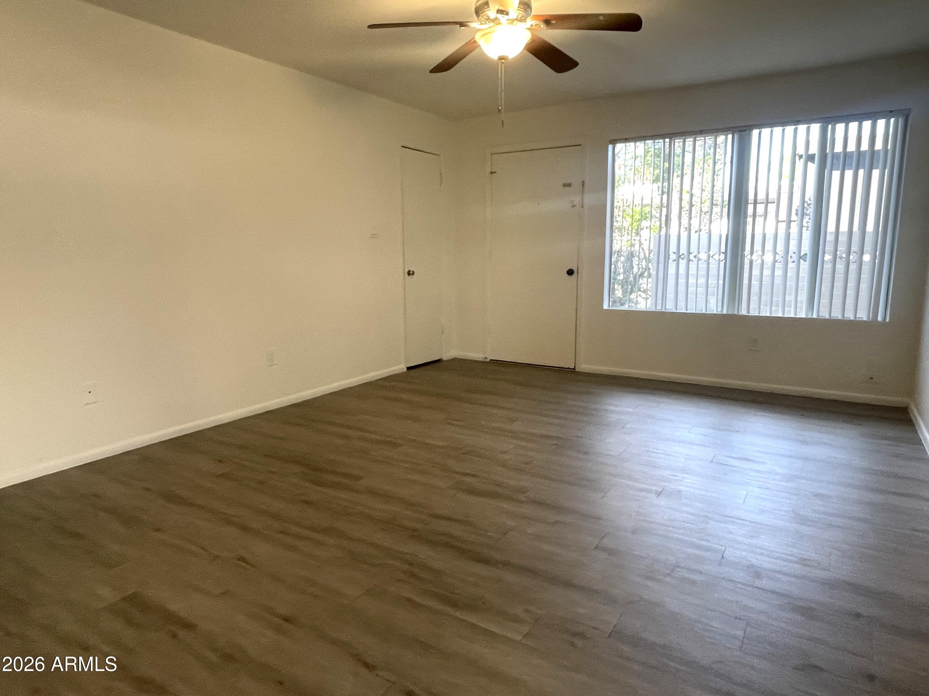 4719 North 15th Avenue, Unit 4 Phoenix, AZ 85015 - Photo 3 of 13 an empty room with wooden floor and windows