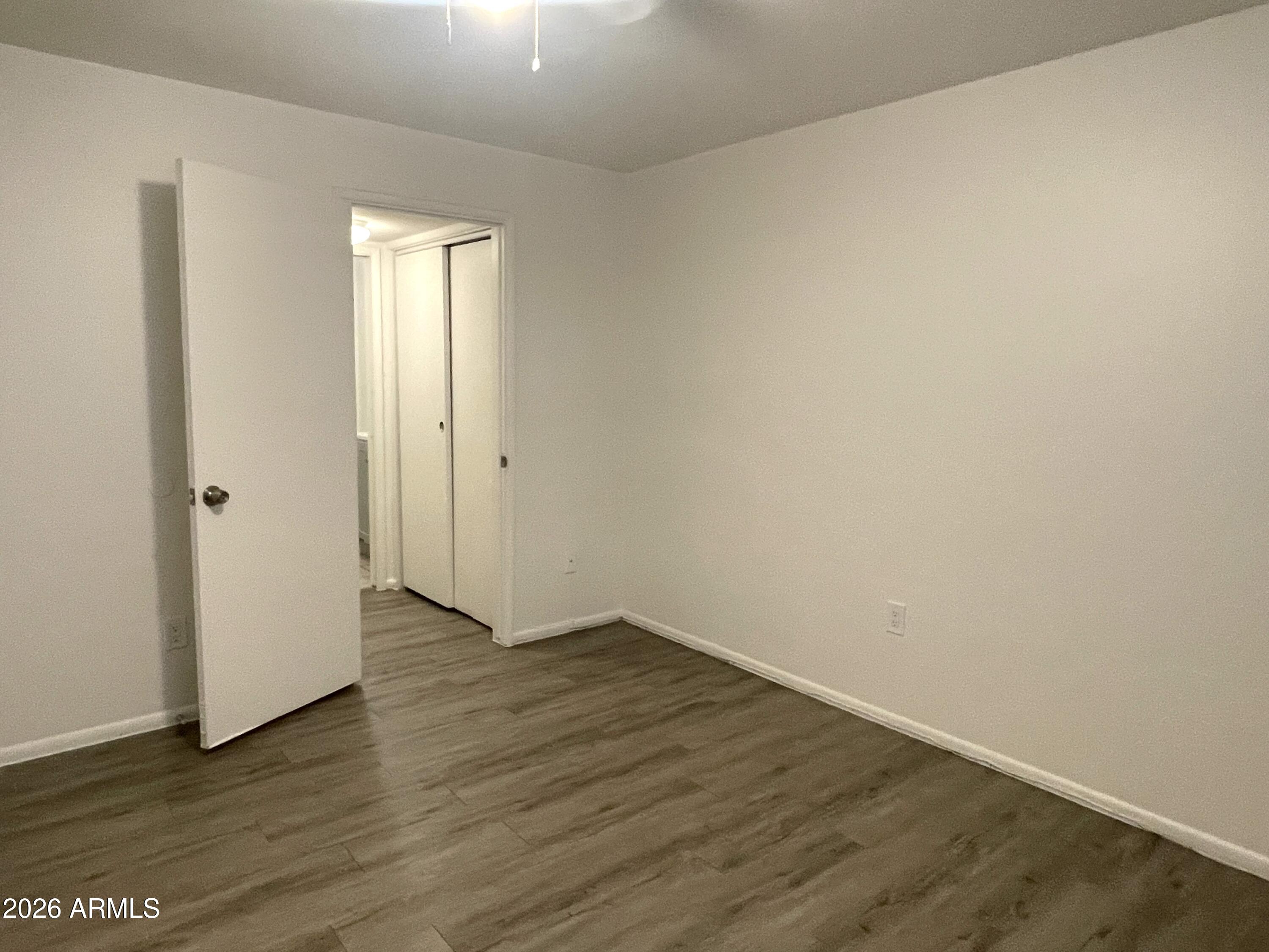4719 North 15th Avenue, Unit 4 Phoenix, AZ 85015 - Photo 8 of 13 a view of an empty room with wooden floor and closet