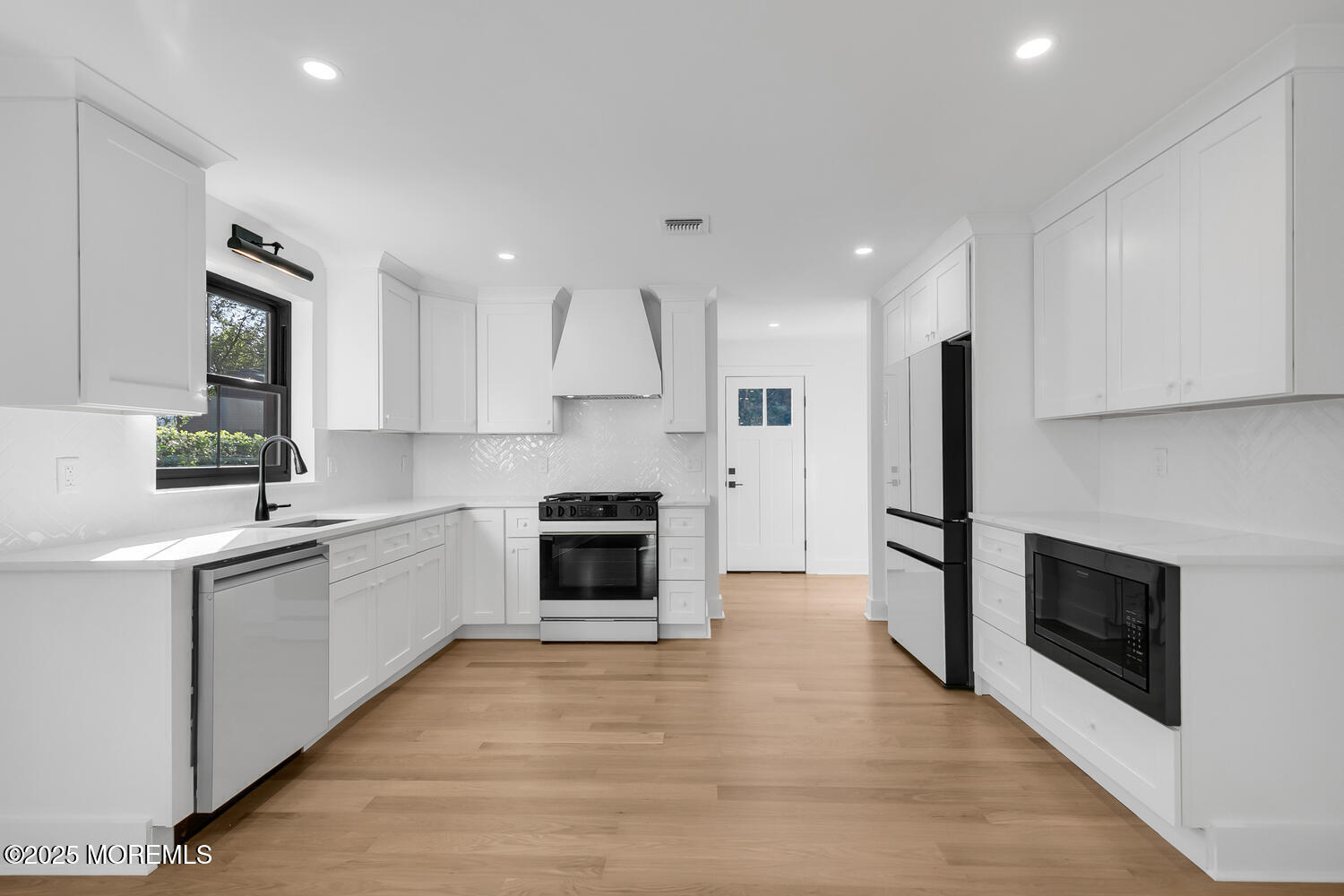 514-516 River Road Fair Haven, NJ 07704 - Photo 7 of 49 a kitchen with white cabinets and stainless steel appliances
