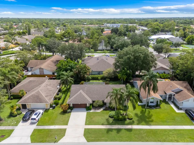 an aerial view of residential houses with outdoor space and city view