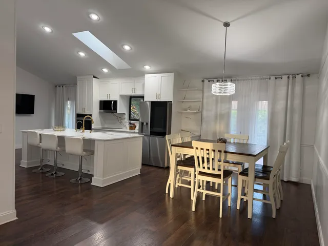 a kitchen with a table chairs refrigerator and microwave