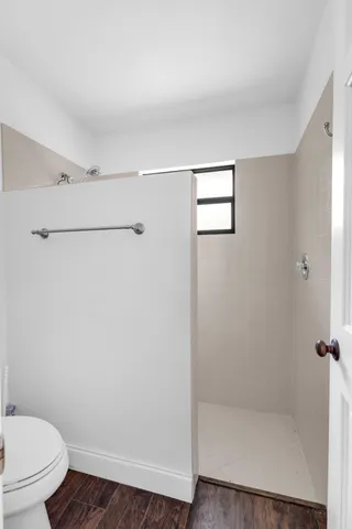 a bathroom with a granite countertop toilet and a shower
