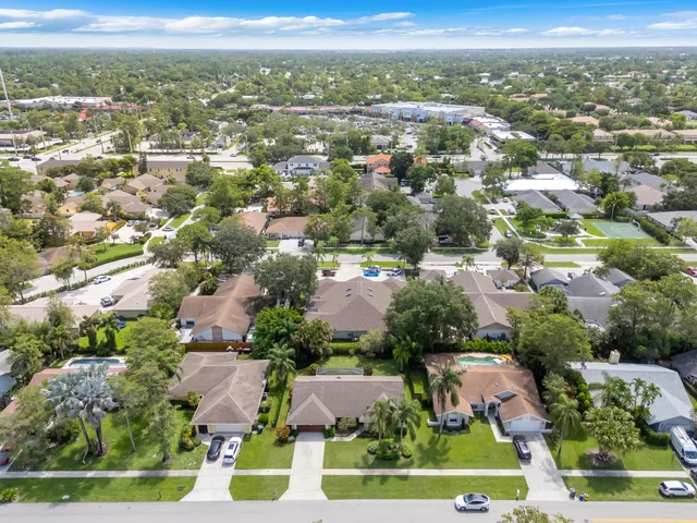 an aerial view of residential houses with outdoor space and parking