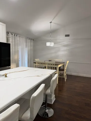 a kitchen with kitchen island stainless steel appliances a table chairs in it and floors