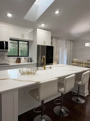 a kitchen with a table chairs sink and cabinets