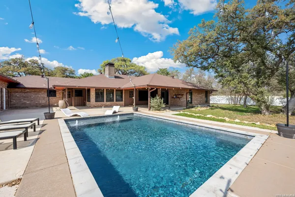 a view of a house with swimming pool and a yard