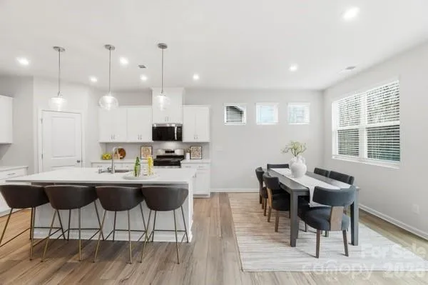 a living room with furniture or couch and a dining table with wooden floor