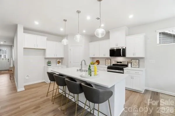a kitchen with a dining table chairs and wooden floor
