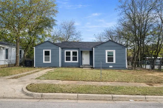 a view of a yard in front of a house with large tree