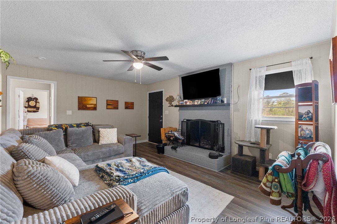 2890 Fulford McMillan Road Raeford, NC 28376 - Photo 12 of 37 a living room with furniture a flat screen tv and a fireplace