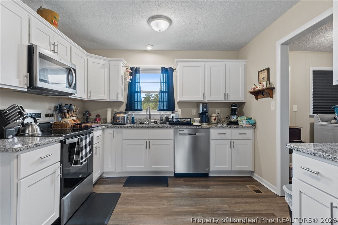 2890 Fulford McMillan Road Raeford, NC 28376 - Photo 13 of 37 a kitchen with granite countertop white cabinets and stainless steel appliances