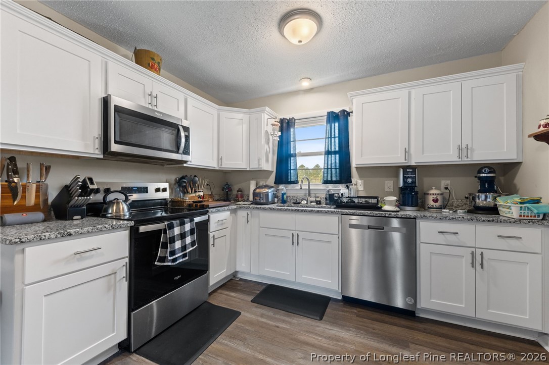 2890 Fulford McMillan Road Raeford, NC 28376 - Photo 15 of 37 a kitchen with stainless steel appliances granite countertop a sink a stove a microwave and cabinets