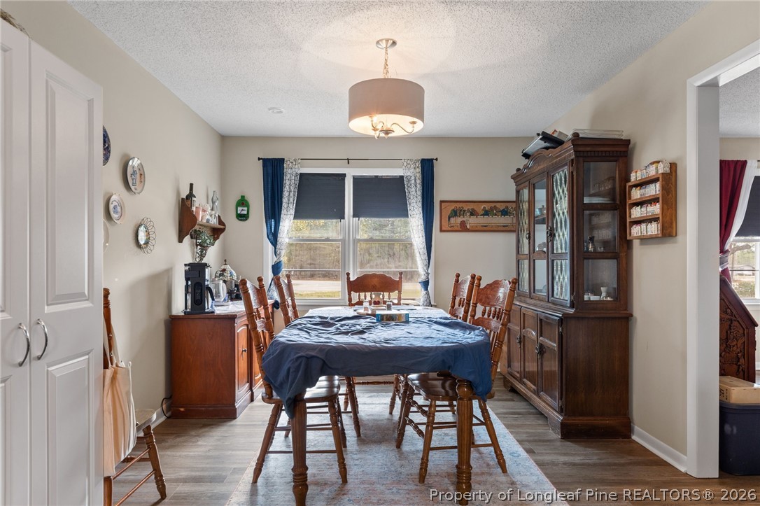2890 Fulford McMillan Road Raeford, NC 28376 - Photo 16 of 37 a view of a dining room with furniture and wooden floor