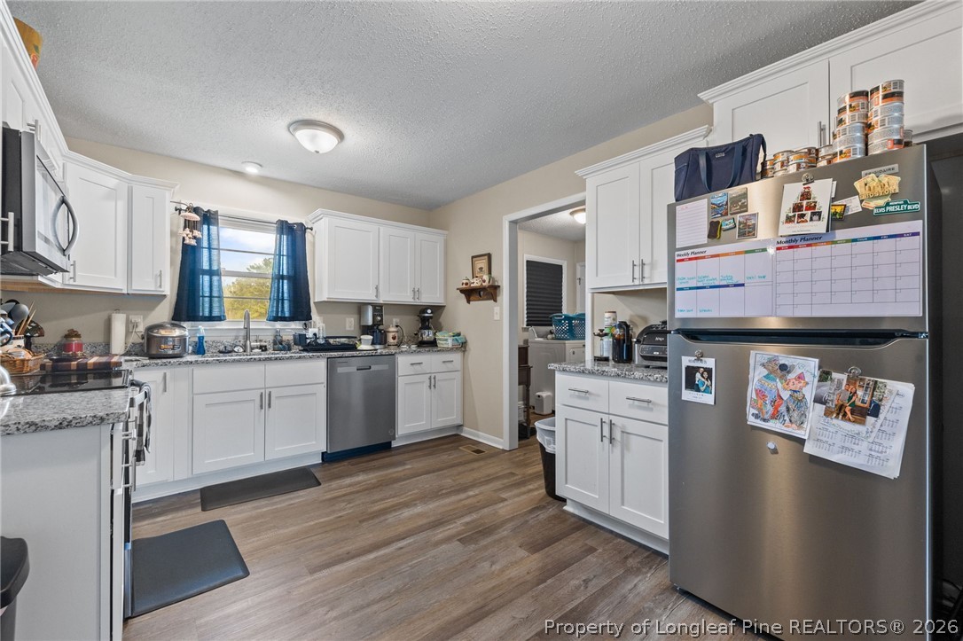 2890 Fulford McMillan Road Raeford, NC 28376 - Photo 6 of 37 a kitchen with stainless steel appliances granite countertop a stove a sink dishwasher and a refrigerator