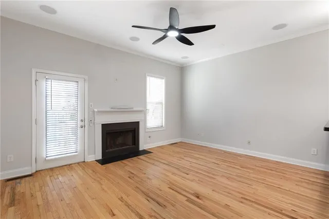an empty room with windows and fireplace