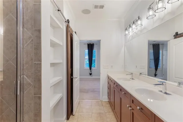 a spacious bathroom with a double vanity sink a large mirror and a shower