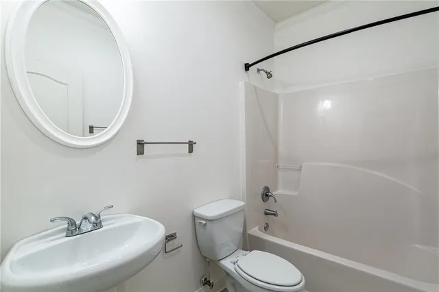 a white toilet sitting next to a bathroom sink