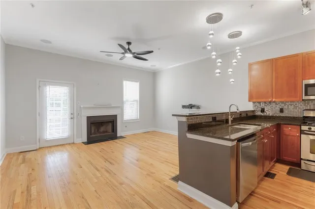 a kitchen with granite countertop a stove top oven a sink and wooden floor