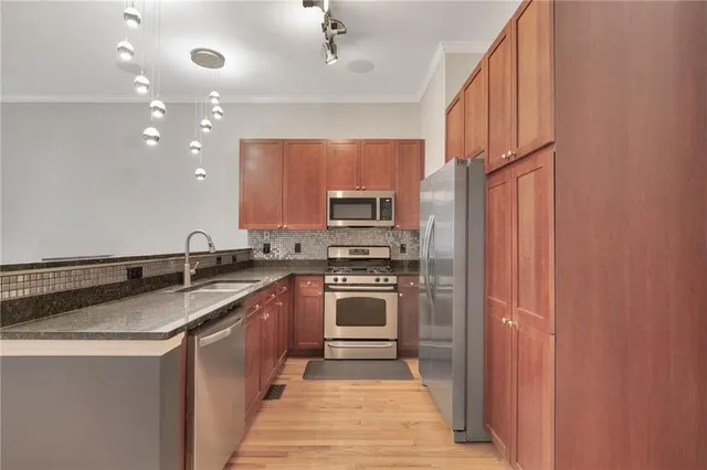 a kitchen with stainless steel appliances granite countertop a sink and stove top oven