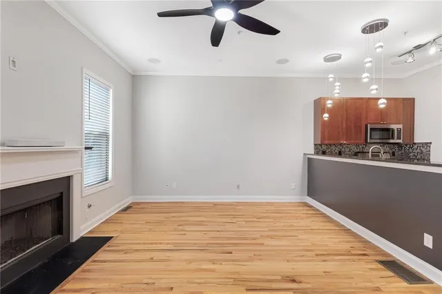 a view of an empty room with a kitchen and a fireplace