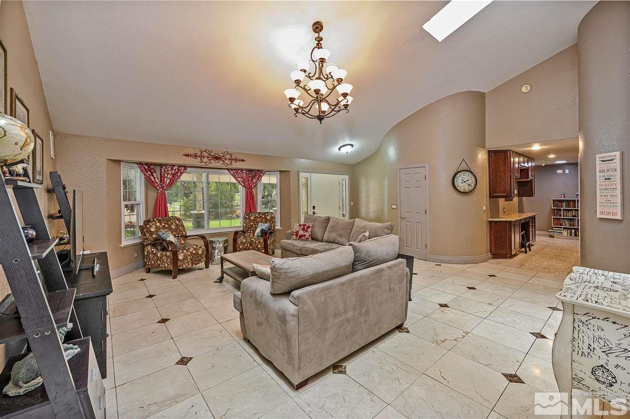 13040 Valley Springs Road Reno, NV 89511 - Photo 15 of 39 a living room with furniture a chandelier and a large mirror