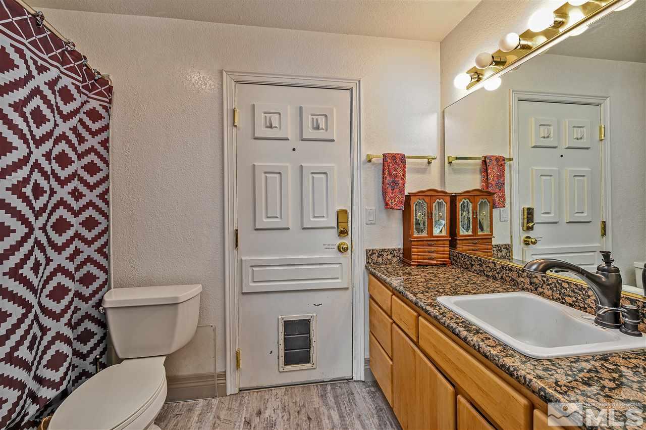 13040 Valley Springs Road Reno, NV 89511 - Photo 23 of 39 a bathroom with a granite countertop toilet sink and mirror