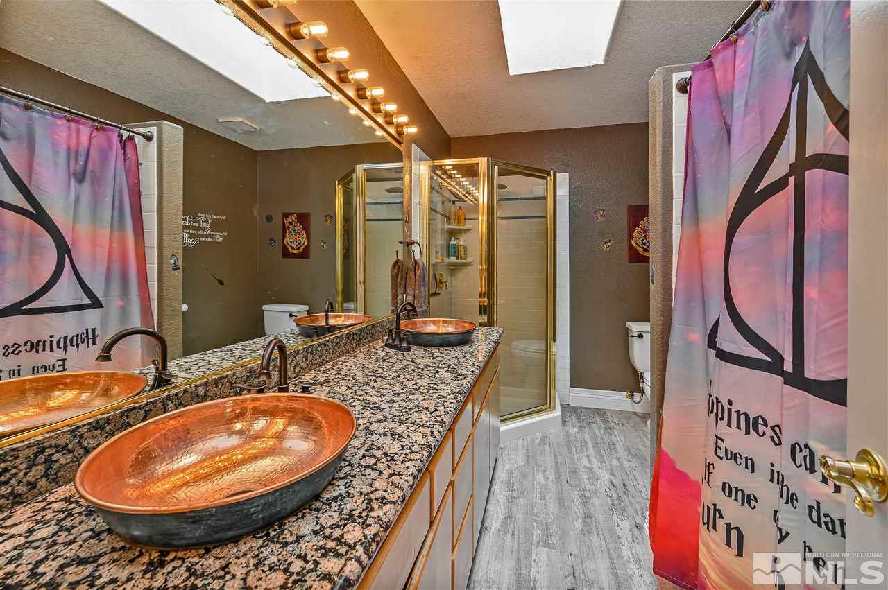 13040 Valley Springs Road Reno, NV 89511 - Photo 28 of 39 a bathroom with a granite countertop sink and a mirror