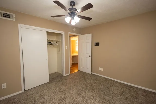 an empty room with a ceiling fan and a window