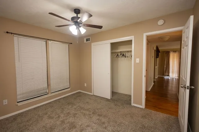 an empty room with fan and entrance