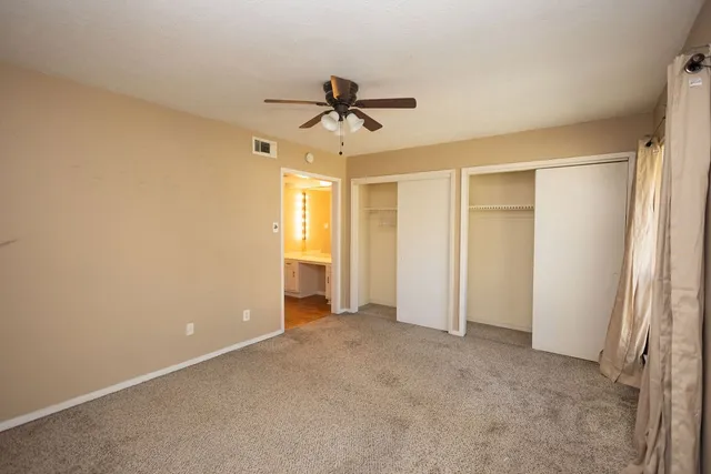 an empty room with windows and fan