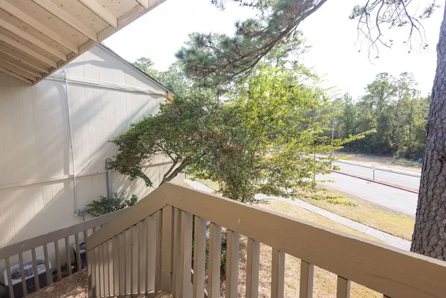 a view of a wooden balcony and trees